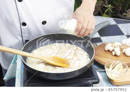 Chef pouring fresh milk the pan for cooking 65707952