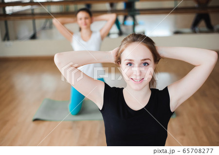 Healthy young women doing exercise on mats for fitness in the gym. Healthy young women doing exercise on mats for fitness in the gym. 65708277
