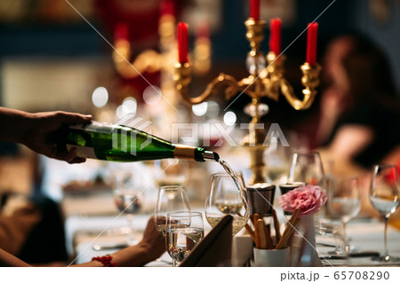 Waiter hand pouring wine in a glass served table Waiter hand pouring wine in a glass served table 65708290