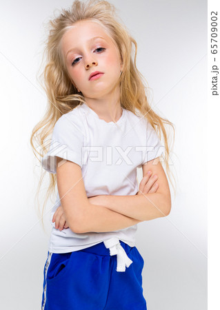 portrait of a young attractive charming blond girl in sportswear with arms crossed on a white portrait of a young attractive charming blond girl in sportswear with arms crossed on a white 65709002