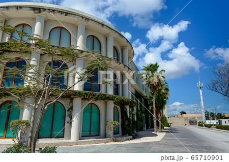 A large building with columns overgrown with ivy. 65710901