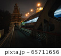 pedestrian railway bridge and lights of a passing train 65711656