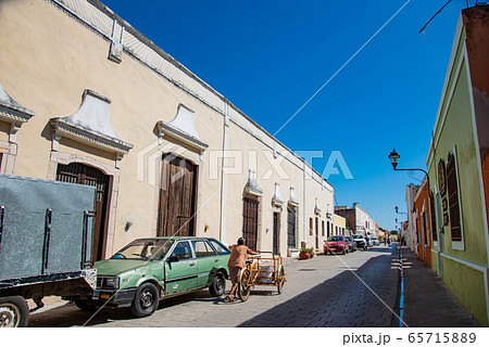 メキシコ　おしゃれなバジャドリの街角　リヤカーを押す年配の女性 65715889