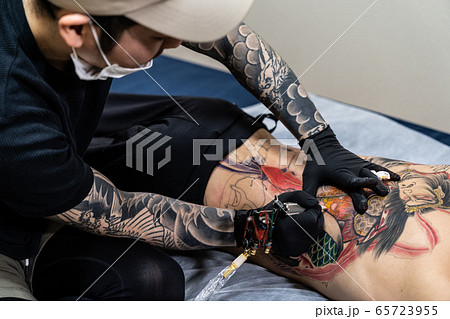 背中に入れ墨する彫り師 刺青 タトゥースタジオの写真素材