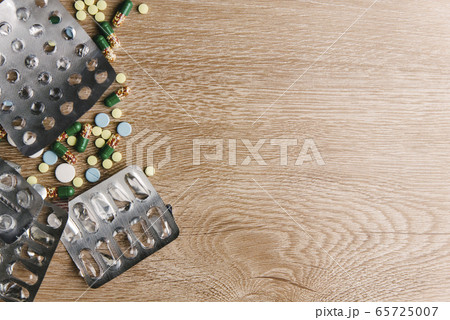 Medical Tablets on a wooden background Medical Tablets on a wooden background 65725007