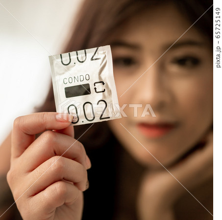Woman is holding a condom ready to be use in Woman is holding a condom ready to be use in 65725149