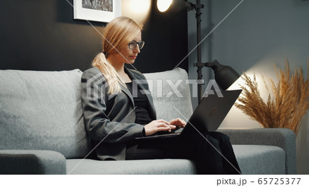 Businesswoman working laptop on couch Businesswoman working laptop on couch 65725377