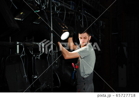The lighting engineer adjusts the lights on stage behind the scenes 65727718