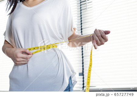 Woman with perfect waist with measuring tape. Woman with perfect waist with measuring tape. 65727749