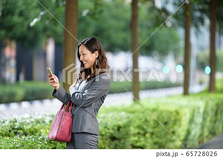Businesswoman using smartphone outdoors Businesswoman using smartphone outdoors 65728026