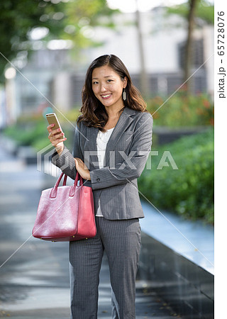 Businesswoman using smartphone outdoors Businesswoman using smartphone outdoors 65728076