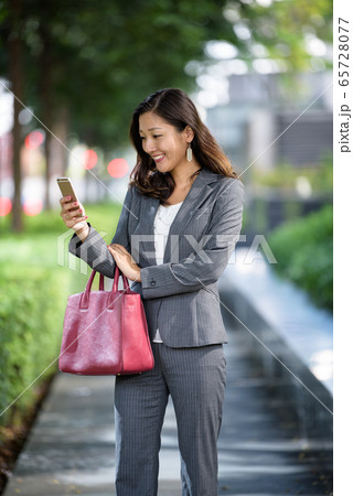 Businesswoman using smartphone outdoors Businesswoman using smartphone outdoors 65728077