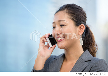Successful businesswoman making voice call outdoors Successful businesswoman making voice call outdoors 65728135