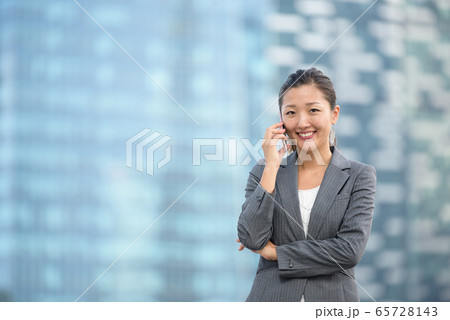 Successful businesswoman making voice call outdoors Successful businesswoman making voice call outdoors 65728143