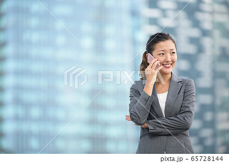 Successful businesswoman making voice call outdoors 65728144