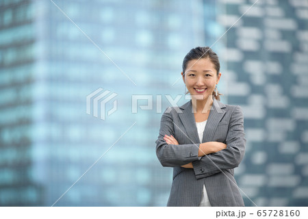 Confident businesswoman standing infront of skyscrapers Confident businesswoman standing infront of skyscrapers 65728160