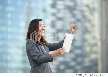 Successful businesswoman using iPad outdoors Successful businesswoman using iPad outdoors 65728172