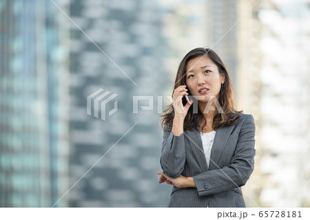 Businesswoman worried look while on voice call, using smartphone, outdoors Businesswoman worried look while on voice call, using smartphone, outdoors 65728181