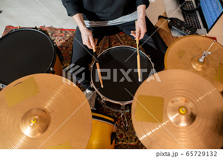 Overview of hands of young drummer or musician with drumsticks having rehearsal 65729132