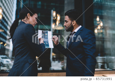 Confident ethnic office worker sharing ideas with boss in workplace 65731991