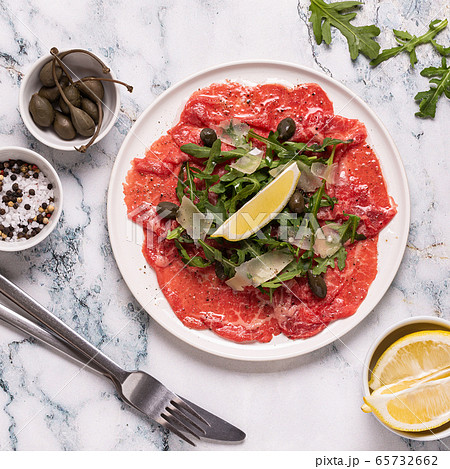 Marbled beef carpaccio with arugula, capers, lemon 65732662