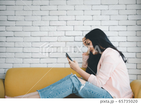 woman looking at smart phone with stress emotional 65735020