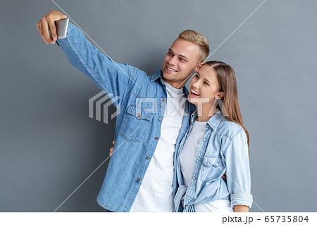 Young couple together free style isolated on grey Young couple together free style isolated on grey 65735804