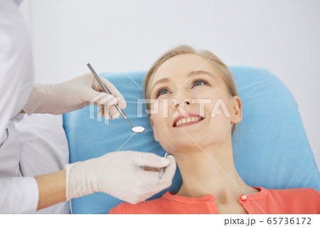 Smiling caucasian woman is being examined by dentist at dental clinic. Healthy teeth and medicine, stomatology concept 65736172