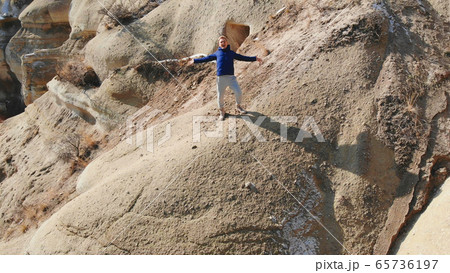 Tourist guy admires World Heritage, Cappadocia, Gereme, Turkey. Beautiful mountains of volcanic origin. 65736197