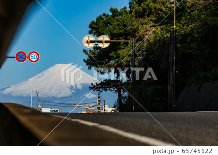 日本の観光名所、稲村ガ崎の爽やかな青空の下にそびえる雄大な富士山に向かう国道134号線 65745122