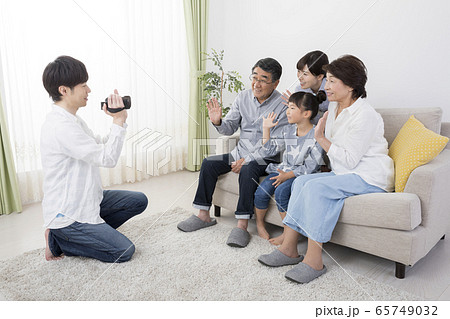 3世代イメージ　家族をビデオカメラで撮影するお父さん 65749032
