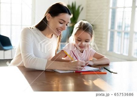 Happy mom and small daughter painting together Happy mom and small daughter painting together 65753686