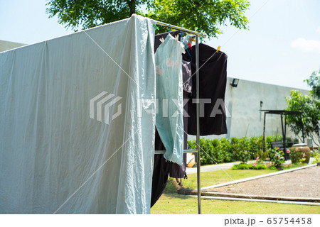 Closeup many pieces of rags hanging with clothespin for drying by the sunlight with blurred landscape background 65754458