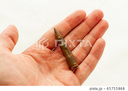 man holds a bullet for assault rifle in his hand 65755868