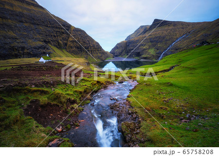 Lake and a small white church in Saksun on the Faroe islands, Denmark. 65758208
