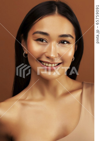 young pretty asian woman cheerful smiling posing on warm brown background, lifestyle people concept young pretty asian woman cheerful smiling posing on warm brown background, lifestyle people concept 65759091