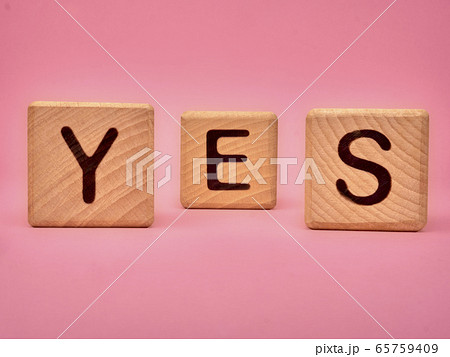 Wooden cubes with the word YES. Three wooden 65759409