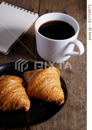 cup of hot coffee  with croissant on dark wooden 65759873