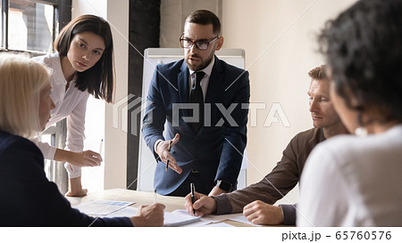 Confident businessman discussing project strategy with mature team leader Confident businessman discussing project strategy with mature team leader 65760576