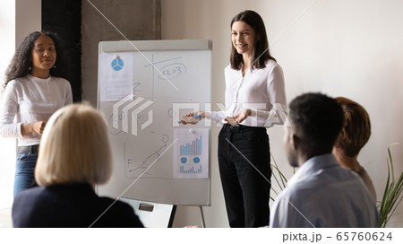 Two diverse business coaches giving flip chart presentation at meeting 65760624