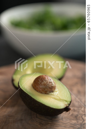Ripe avocado sliced in halves on olive wood board with copy space 65760965