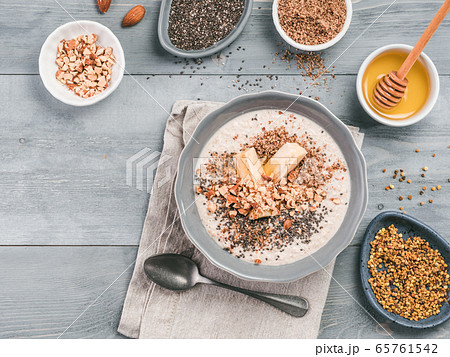 Overnight oats in bowl and ingredients on gray wooden table Overnight oats in bowl and ingredients on gray wooden table 65761542