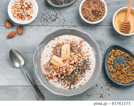Overnight oats in bowl and ingredients on gray wooden table 65761575