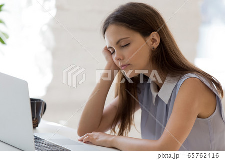 Exhausted young female fall asleep at workplace Exhausted young female fall asleep at workplace 65762416