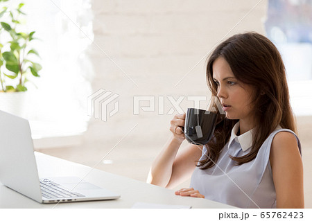 Tired woman worker look at laptop lacking work motivation 65762423