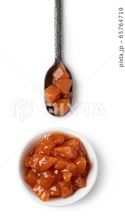 Small glass bowl and spoon of apricot jam 65764719