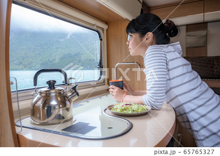 Woman in the interior of a camper RV motorhome 65765327