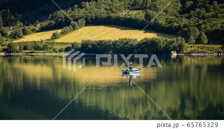 Woman fishing on a boat. 65765329