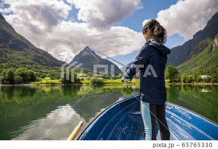 Woman fishing on a boat. Woman fishing on a boat. 65765330