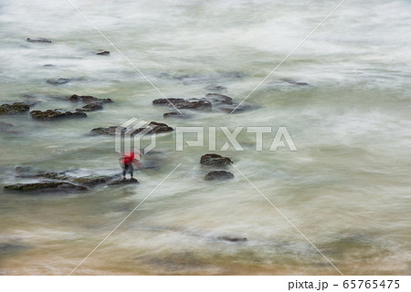 Long exposure photograph of a shellfisherman working on the rocks at Seixo beach, Torres Vedras 65765475